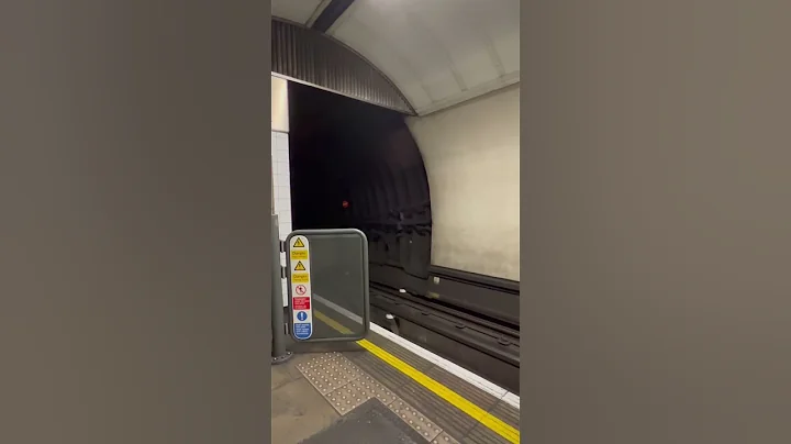EXTREME SPEED, London underground train approaches platform at high speed.