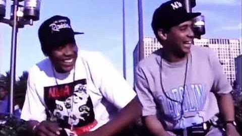 Eazy-E runs past Dre & Yella with an uzi during an interview