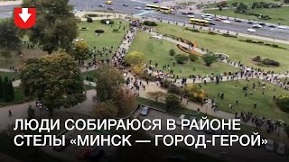 Люди с флагами собираются у стелы «Минск — город герой»