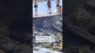 Un uomo è stato ripreso mentre defecava in pubblico sotto agli scogli, vicino ad alcune ragazze.