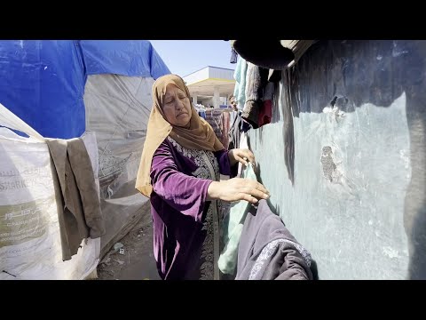أمهات فلسطينيات يمارسن حياتهن اليومية في "يوم الأم" بمخيمات النزوح في دير البلح وسط قطاع غزة