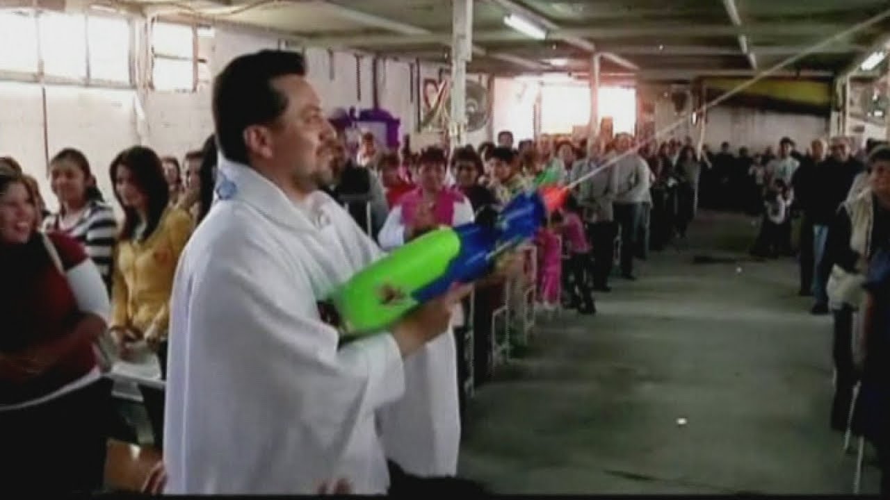 Mexican priest uses watergun to spray holy water - YouTube