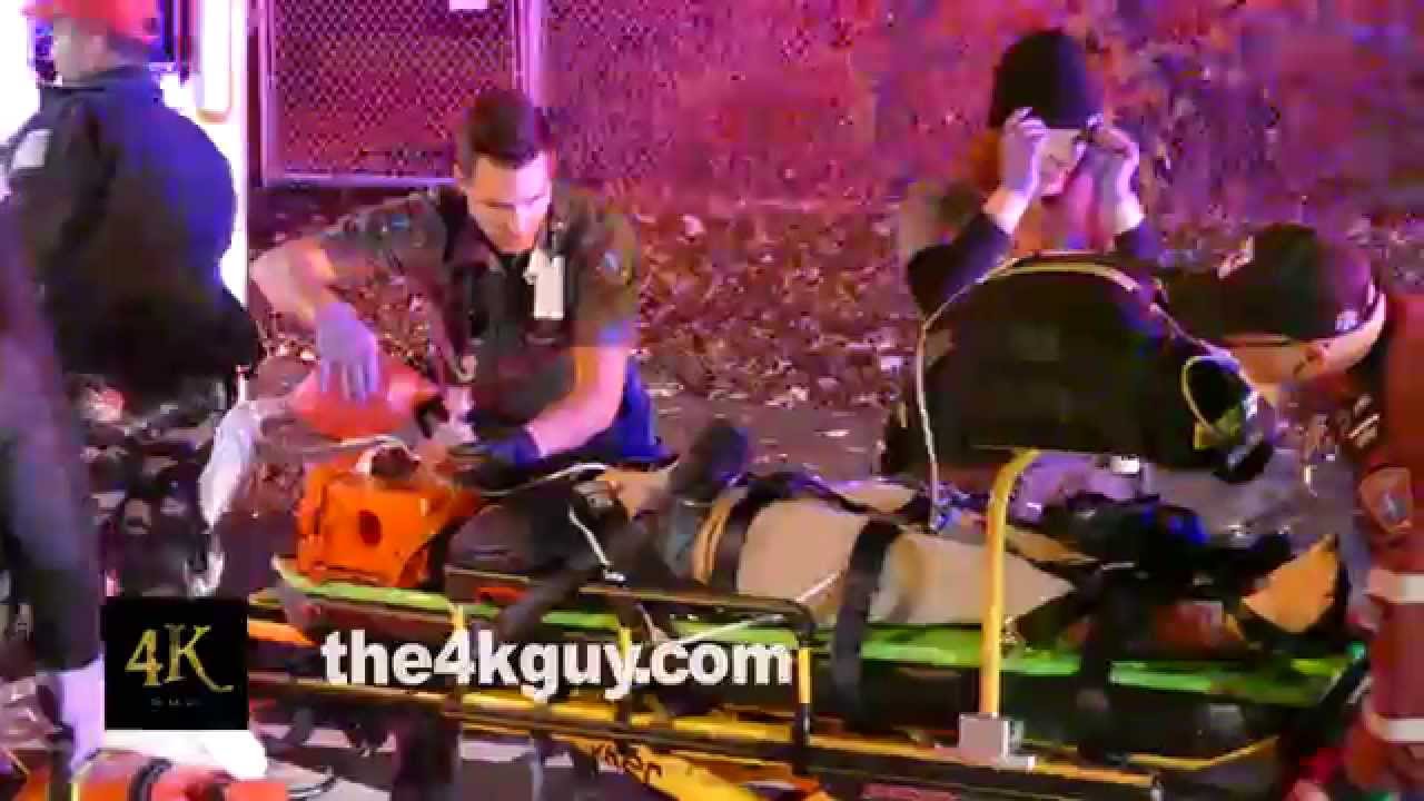 4K UHD - Ambulance crew loading female patient with head trauma into ...