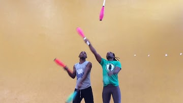 2 people in clubs juggling by Rwandan acrobats