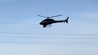 Helicopter removing marker cones from power line.