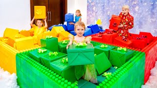 Cinq enfants jouent à des jeux et à des défis avec des cadeaux à Noël