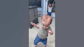 Cute twin babies walking together outside