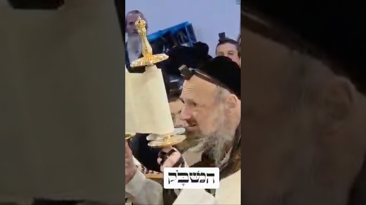 הגה"צ הרב דב קוק עושה הבוקר הגבהה בספר תורה קטן שהוכן במיוחד עבורו