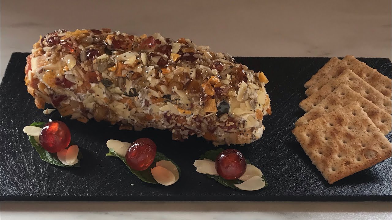 Rulo de queso con semillas, frutos secos y frutas confitadas