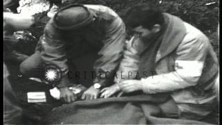 Medics remove a bandage from the head of a wounded soldier at a medical aid stati...HD Stock Footage