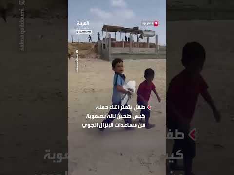 طفل يحاول الحفاظ على كيس طحين من المساعدات