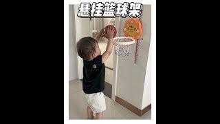 Baby's daily routine includes dad's basketball hoop for motor development and growth.