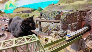 The giant black cat watching over the train is adorable