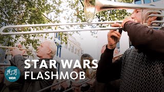 Star Wars Flashmob in Cologne / Germany | WDR Rundfunkorchester | ARD(On the 1st of October the WDR Radio Orchestra mingled with the crowds on Cologne Wallrafplatz and surprised with well-known tones from a galaxy far, ..., 2012-10-10T11:32:06.000Z)