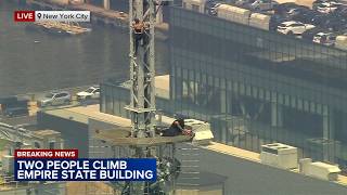 2 people climb to top of Empire State Building with pro-peace banner