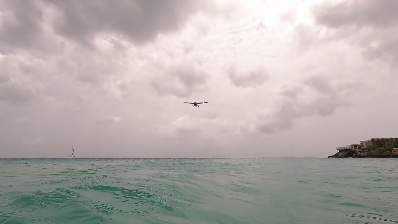 Little plane flying over Maho Beach, Sint Maarten upside down