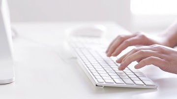 close up of hands typing on computer keyboard 1 4KUQ8XJ
