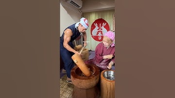 A muscular Japanese man making mochi