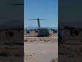A U.S. Air Force C-17 Globemaster III lands and takes off on a dirt runway.