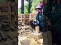 splitting a block of natural stone using chisel and hammer into smaller pieces for building project
