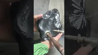 polishing a dark stone with a rotary tool and water to create a smooth surface and floral patterns