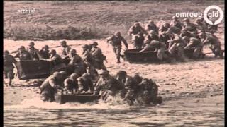 Militairen en burgers lopen de 504e Sunset March over De Oversteek bij Nijmegen