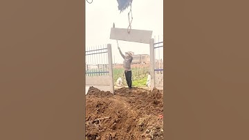 The process of installing a fragment of a concrete fence with the help of an excavator
