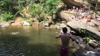 Guy cliff dives and lands on part of cliff before reaching water