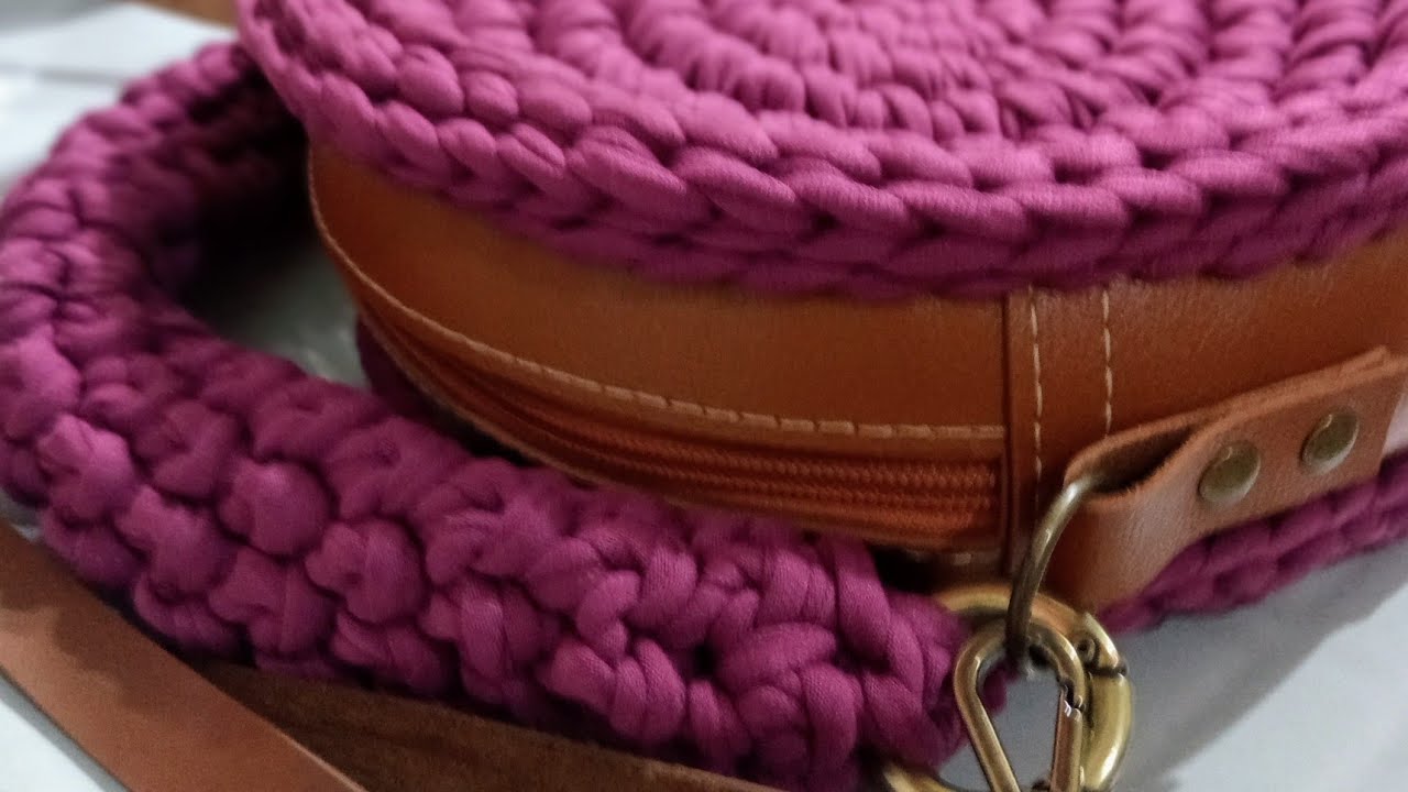 Bolsa redonda de crochê com base em couro sintético.