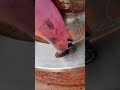 Welding a metal piece onto a rusty circular iron part using a handheld welding torch indoors