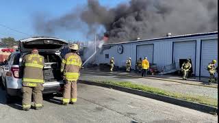 Flames Still Climb Out of the Roof of the Structure