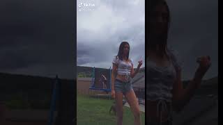 Girl dances for TikTok video as boy attempts front flip from trampoline in the background