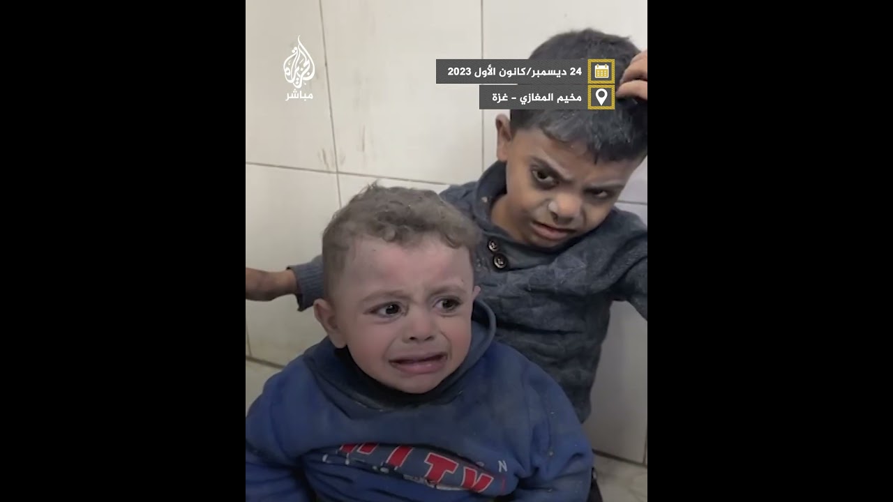 طفل يحتضن رضيعا بعد نجاتهما من مجزرة مخيم المغازي في غزة