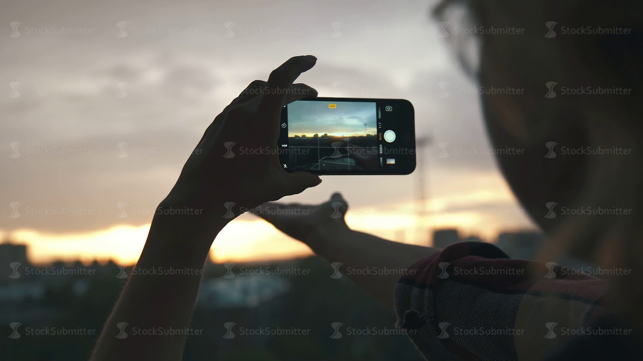 women's hands hold mobile phone, photographing horizontal