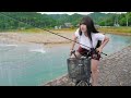 雨に濡れながら魚を釣って食べる女。