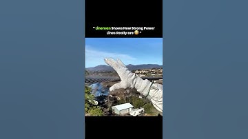 A lineman works high above, using tools and safety skills to handle live power lines with precision.