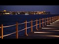 Stunning And Amazing Empty Wooden Bridge Illuminated By Lanterns On The Shore Of The Red Sea 