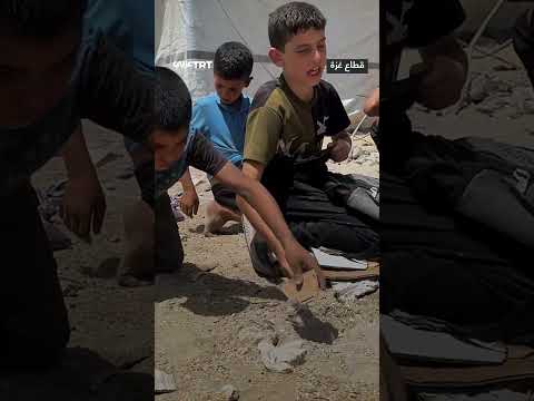 أطفال يجمعون حبوب المساعدات من الرمل