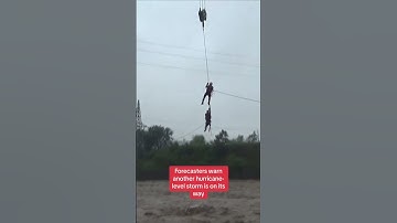 Rescue workers save a man from his car as China is hit by one of the worst typhoons in years
