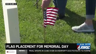 Volunteers place flags on service members’ graves for Memorial Day