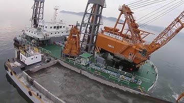 A huge excavator with a clamshell bucket, dredging