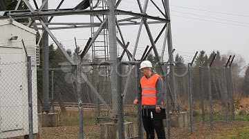 Engineer at GSM tower with a cell phone and folder. Stock Footage