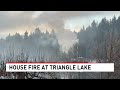 Firefighters battle house fire near Triangle Lake
