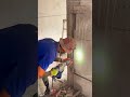 breaking a concrete pillar wall using a powerful electric demolition jackhammer tool inside a room