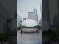 Handheld scene of people visiting Cloud Gate, famous public sculpture in Chicago's Millennium Park