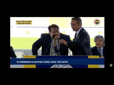 Ali Koç, Oktay Uludoğan'ın başkan adayı olacağını söylerken mikrofonunu düzeltiyor
