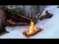 Building winter survival shelter for a night by the campfire