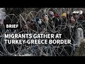 Migrants gather behind barbed wires at the border between Turkey and Greece | AFP