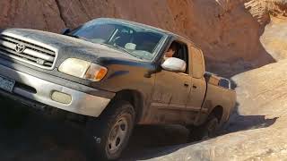 Stock Toyota Tundra climbs Hell's Gate in Moab UT with carnage
