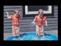 Twins play on splash pad